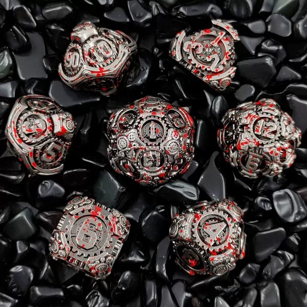 In-stock silver steampunk gear metal dice with red blood-splatter finish