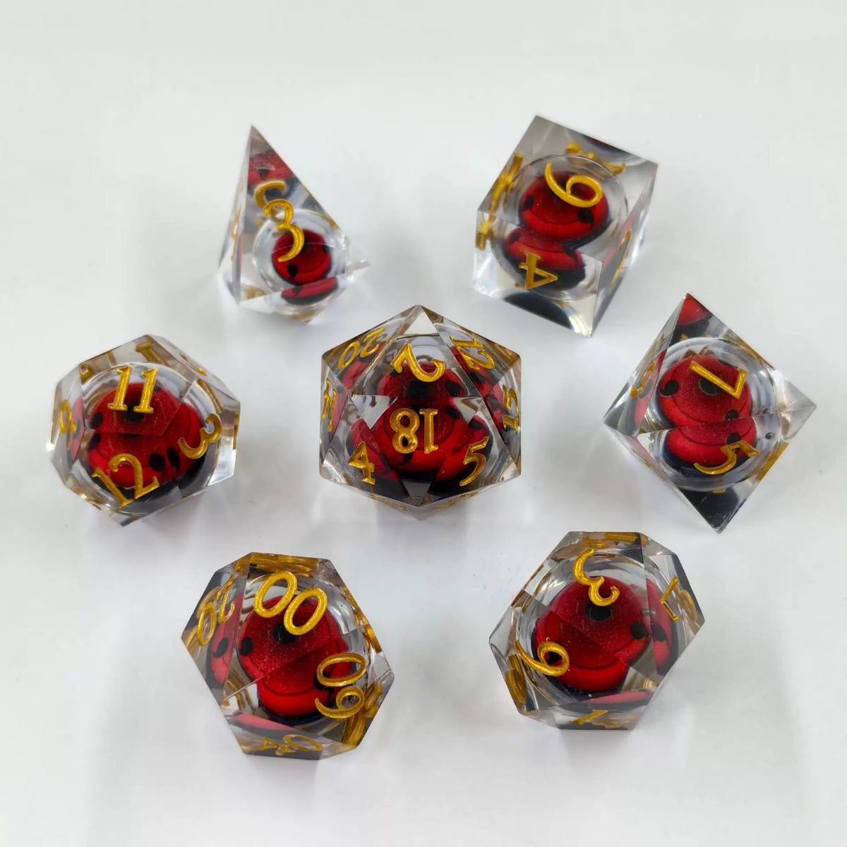 Sharp-edge resin polyhedral dice with a red liquid core and gold numbers